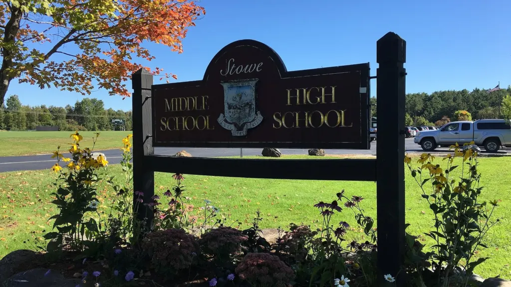 The sign for Stowe Middle High School on a sunny day with fall foliage