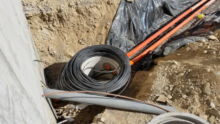 Fiber-optic cable being installed in a trench (illustrative)